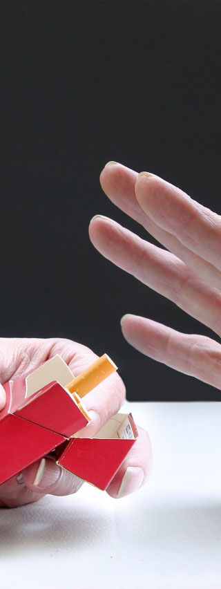 Photo of hands, one is offering a cigarette, the other is rejecting it